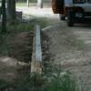 Treated timber wall being used to stabilize driveway edge.